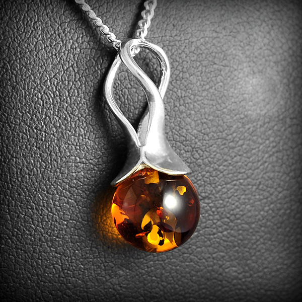 Joli pendentif en argent très actuel, il met en valeur la transparence de l'ambre véritable de la...