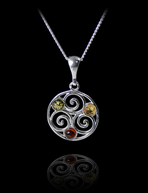 Pendentif d'un beau triskell en argent ajouré et cerclé, serti de trois perles d'ambre véritable...