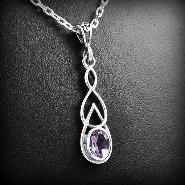 Joli pendentif en argent composé d'un entrelacs et serti d'une petite pierre d'améthyste...