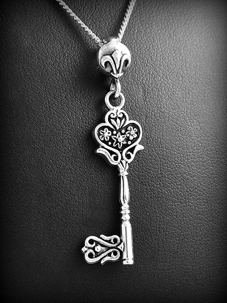 Pendentif en argent  d'une très belle clé, une petite fleur de lys décore la bélière, finition...