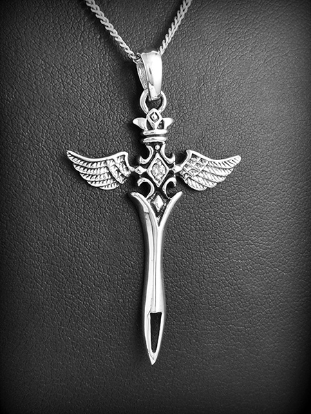 Pendentif d'une belle dague en argent, la pointe de la lame est perforée, la poignée est formée...