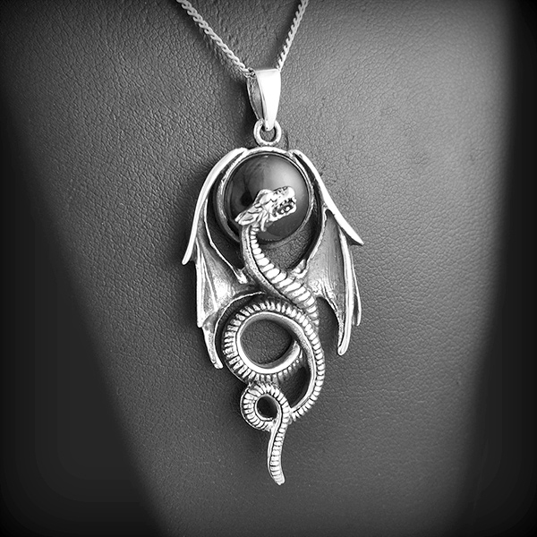 Pendentif en argent d'un beau dragon ailé protégeant un cabochon d'onyx noir (h:55mm).