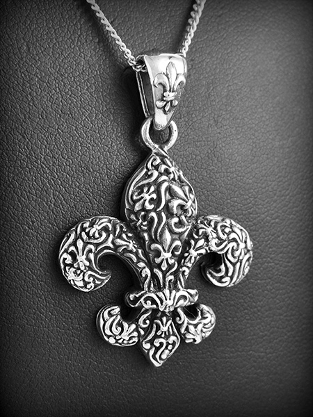 Très beau pendentif en argent d'une fleur de lys découpée en volume gravée de petites fleurs de...