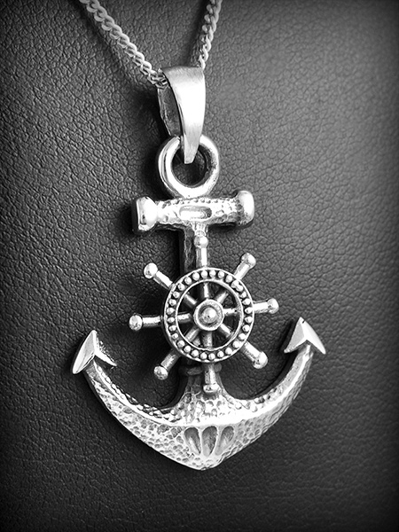 Pendentif en argent d'une belle ancre marine en volume ornée d'une barre de bateau au centre...