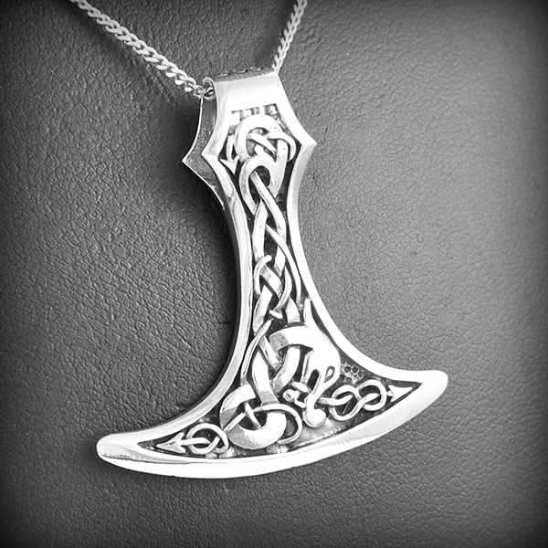 Joli pendentif en argent d'une arme tranchante ornée des deux cotés de motifs celtiques, la...