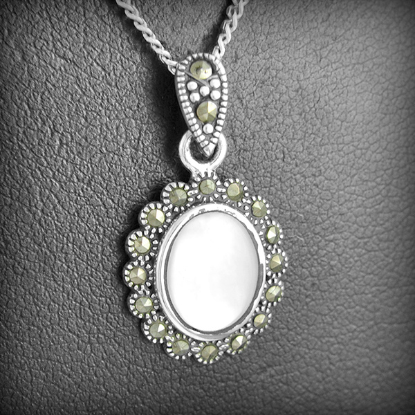 Pendentif en argent d'une nacre banche sertie de petites marcassites, la bélière est également...