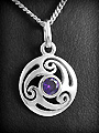 Pendentif en argent d'un disque ajouré formant un triskel élégant, et serties d'un zircon violet...