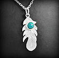 Superbe pendentif en argent d'une plume ornée d'une petite pierre de turquoise reconstituée de...